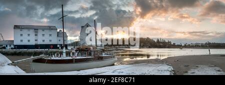 WOODBRIDGE, SUFFOLK, UK - FEBRUARY 11, 2010:  Panorama view of the Tide Mill at dawn seen over boat tied up on the River Deben beside the slipway Stock Photo