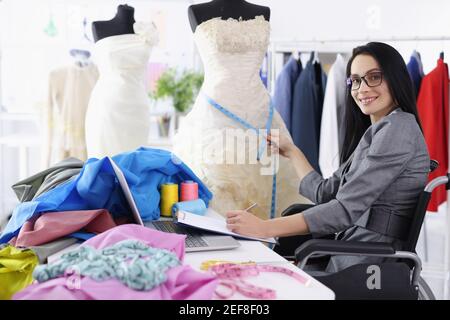 Disabled woman designer provides services for sewing wedding dresses Stock Photo