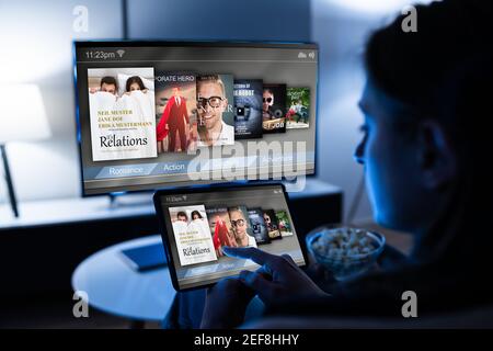 Woman Watching TV Through Tablet Television And Movie Streaming Stock Photo