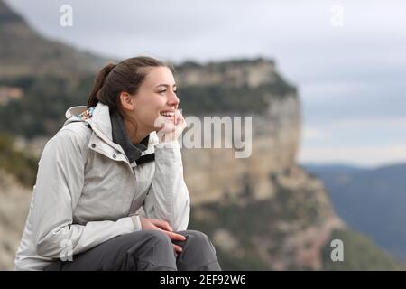 Happy trekker contemplating views sitting outdoors in the mountain Stock Photo