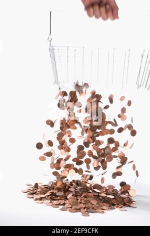 Coins draining from a metal basket Stock Photo