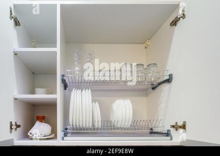 set of plates, cups and wine glasses on the shelf in the kitchen cabinet Stock Photo