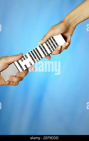 Close-up of a man and a womanÅ½s hands holding a remote control Stock Photo