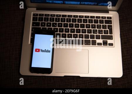 Smartphone with Youtube logo resting on a laptop's keyboard. YouTube is an American online video-sharing platform, one of the most visited websites. Stock Photo