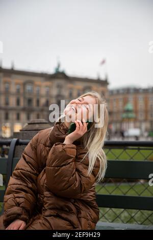 A beautiful girl is making a great phone call and she is very happy, pleased and smiling Stock Photo