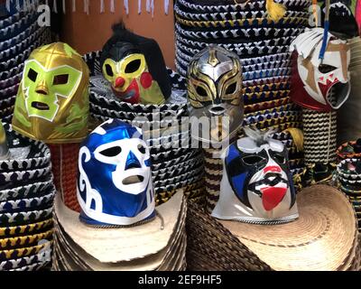 MEXICO CITY, MEXICO - Feb 17, 2018: A selection of colorful Lucha Libre Mexican professional wrestling masks, for sale, on top of wide-brimmed Mariach Stock Photo