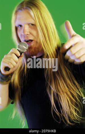 Close-up of a mid adult man singing into a microphone Stock Photo