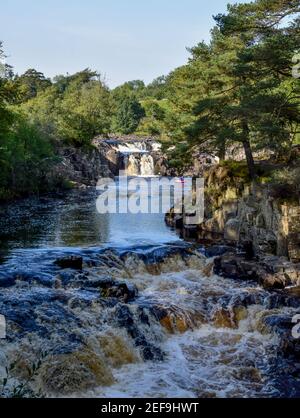 Low force Waterfall on a sunny day with Kayakers enjoying the river and its force Stock Photo