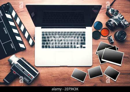 Vintage retro camera with clapboard and old photos on wooden background, clipping path Stock Photo