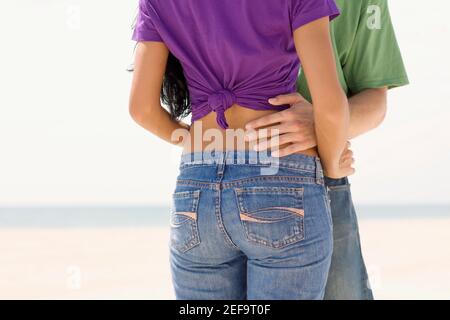 Mid section view of a young couple embracing each other on the beach Stock Photo