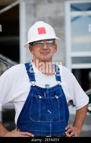 Portrait of a construction worker standing with arms akimbo Stock Photo