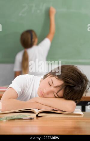 Schoolboy napping on a desk in a classroom Stock Photo