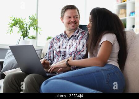 Man and woman sitting on couch with laptop Stock Photo