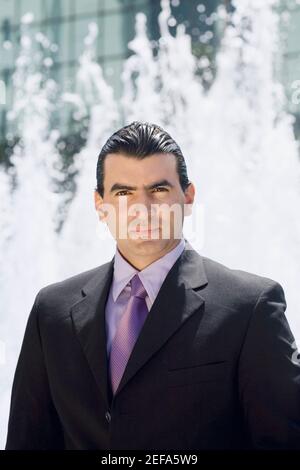 Portrait of a businessman with a fountain in the background Stock Photo