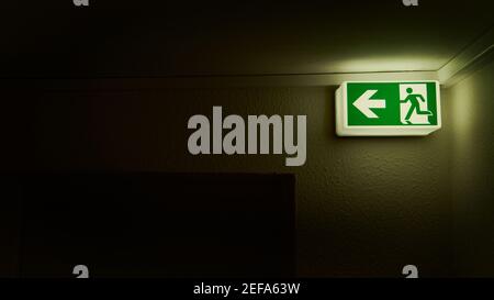 Luminous emergency exit symbol for fire safety in the house Stock Photo