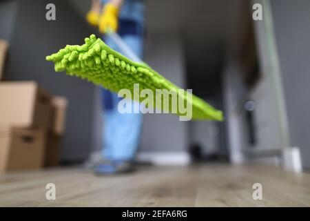 Worker holds mop with green rag for floor Stock Photo