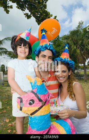 Portrait of a mid adult couple celebrating birthday with their daughter Stock Photo