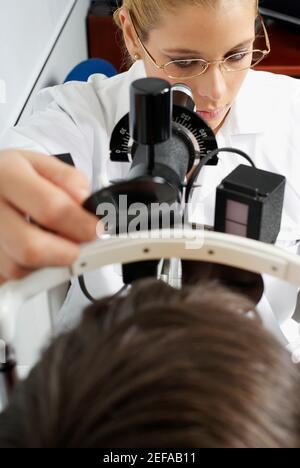 Close-up of a female optometrist examining eyes of a patient Stock Photo