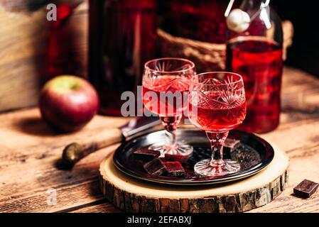 Homemade red currant nalivka and chocolate on metal tray Stock Photo