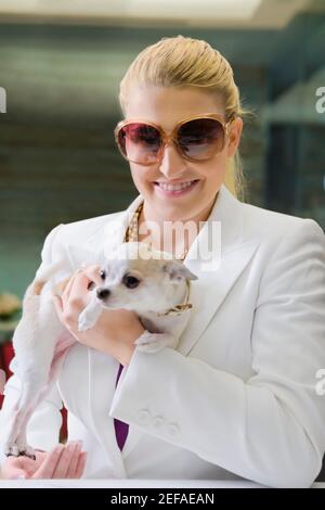 Businesswoman holding a puppy and smiling Stock Photo