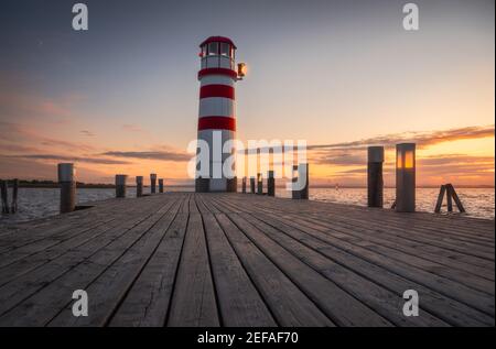 Wooden Pier Floor under Lighthouse on Neusiedl Lake, Austria at Sunset Stock Photo