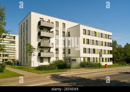 Apartment building in a prefabricated housing estate on the street with a bus stop during the day Stock Photo