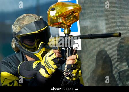 Close up of a mid adult man aiming with a paintball gun Stock Photo