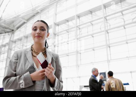 Businesswoman putting a passport with an airplane ticket in her coatÅ½s pocket Stock Photo