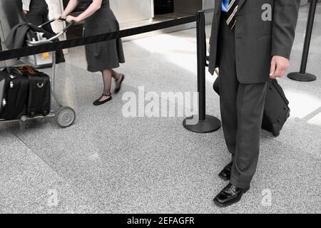 Low section view of a businessman pulling his luggage Stock Photo