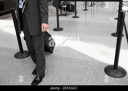 Low section view of a businessman pulling his luggage Stock Photo
