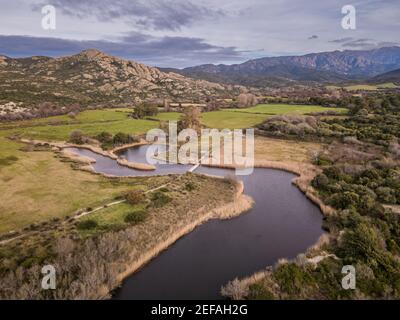 Aerial view of pontoon bridge crossing the river at Ostriconi in the Balagne region of Corsica with mountains in the distance Stock Photo