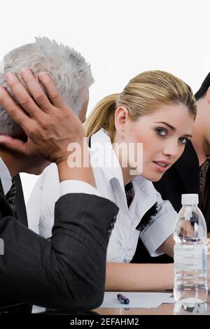 Two businessmen and a businesswoman at a meeting in a conference room Stock Photo