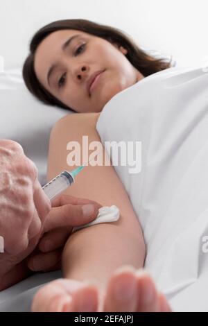 Young woman getting an injection on her hand Stock Photo