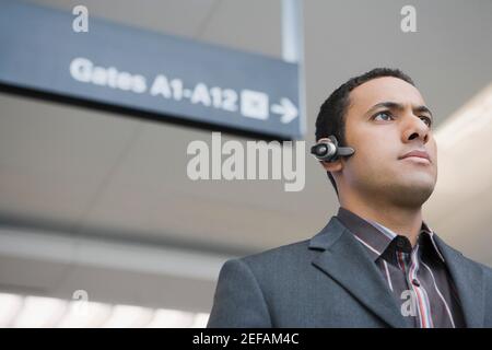 Low angle view of a businessman wearing a hands free device at an airport Stock Photo
