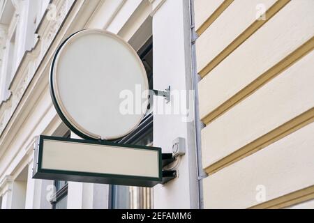 Round sign with neon tubes as a mock-up template on a building for outdoor advertising Stock Photo