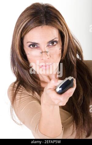 Portrait of a mid adult woman holding a remote control Stock Photo