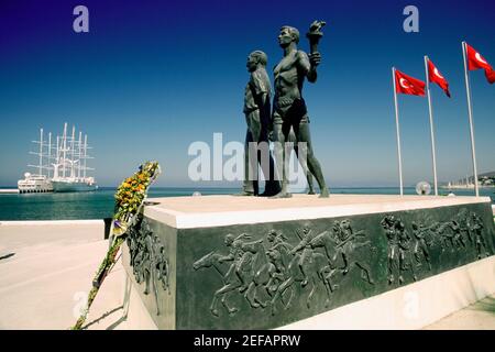 Statues at a monument with flags of Turkey, Monument of Ataturk and Youth, Kusadasi, Turkey Stock Photo