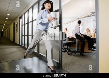Businesswoman carrying disposable cups Stock Photo
