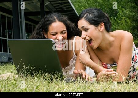 Female university students working on a laptop and laughing Stock Photo