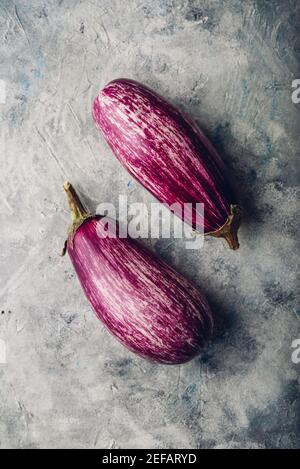 Two fresh purple eggplants on light concrete background Stock Photo