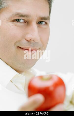 Portrait of a mature man holding an apple Stock Photo