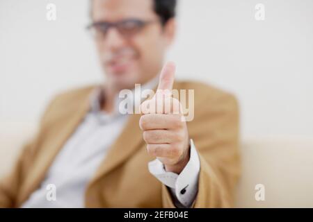 mid adult man giving a thumbs up sign Stock Photo