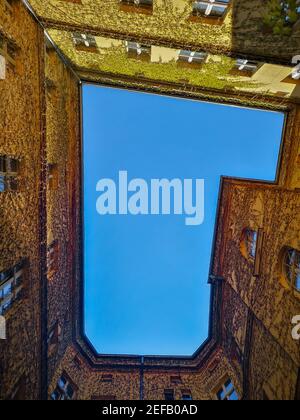 Wroclaw Poland April 16 2019 Upward view to huge well in L shape of roof of old tenement house full of ivy on walls Stock Photo