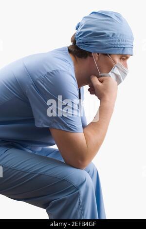Side profile of a male surgeon and three female surgeons looking at a ...