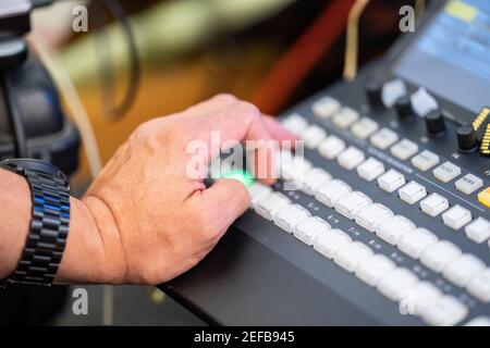 Focus on man's hand how control the livestreaming switcher board. Stock Photo