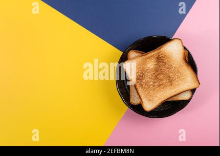 baked bread on three colors(blue,pink,yellow) background. Stock Photo