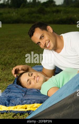 Portrait of a young couple lying on a sleeping bag on the lawn Stock Photo