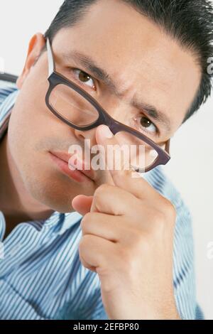 Portrait of a mid adult man adjusting his eyeglasses Stock Photo