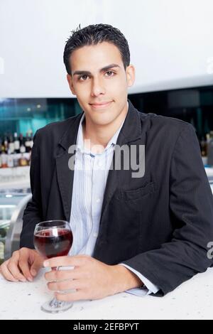 Portrait of a businessman with a glass of wine at a bar counter Stock Photo