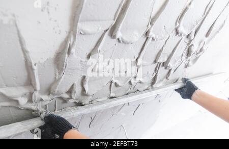 Builder Level out defects in concrete walls with cement plaster. Stock Photo